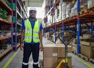 Portrait of male supervisor standing one person at storage shelf in warehouse looking at camera. Confident multiracial logistic manager employee wear safety uniform working with stock in storehouse.