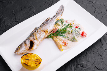 fish with broccoli and sauce on a white plate