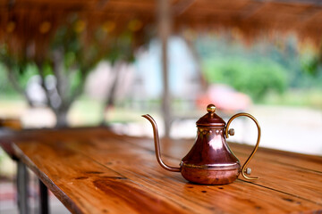 old stlye tea pot on wood table with blur background