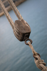 Details of the rigging of a sailing ship against the background of sea water - 671571446