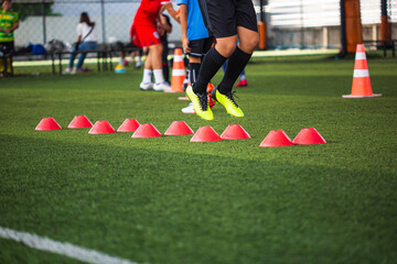 Soccer ball tactics on grass field with barrier for training children jump skill