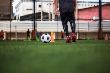 Children playing control soccer ball tactics on grass field with for training