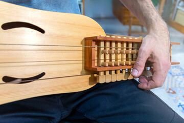 Musician revising the sound of the organistrum in his luthier's workshop.