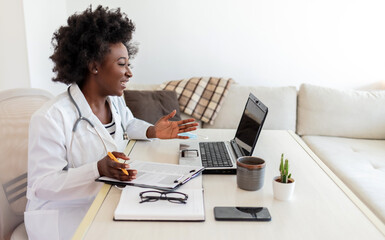 African female doctor consulting patient make online webcam video call on laptop. Black woman...