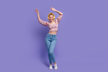 Full body portrait of charming cheerful lady listen favorite song headphones dancing empty space isolated on purple color background
