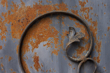 Old and rusty forged decor on a metal fence. Close-up