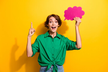 Photo of thoughtful smart lady wear green shirt pointing finger holding mind cloud empty space isolated yellow color background