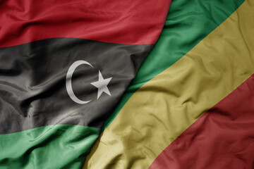 big waving national colorful flag of libya and national flag of republic of the congo .