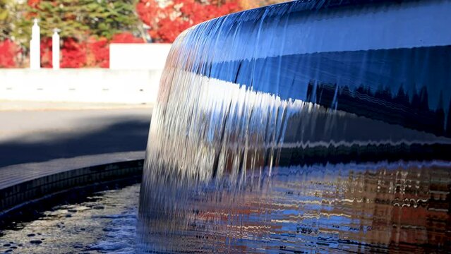 紅葉を背景とした水盤の水の流れ