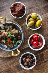 Assorted appetizers for wine, artichoke, pickled vegetables.