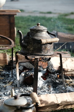 Vieille bouilloire rouill&eacute;e chauffant sur un feu de bois