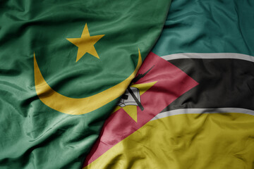 big waving national colorful flag of mauritania and national flag of mozambique .