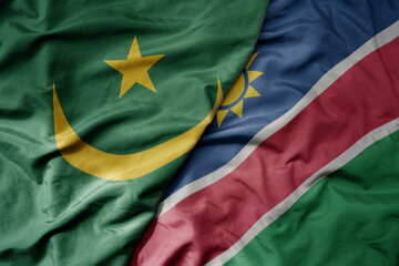 big waving national colorful flag of mauritania and national flag of namibia .