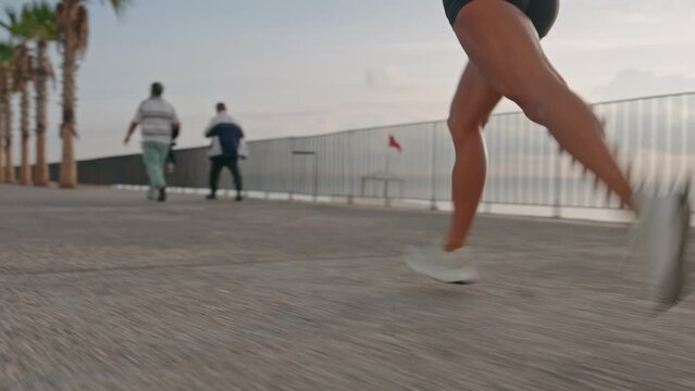 Tracking shot of Young fitness sports woman running outdoors on the promenade during sunset. High quality 4k footage