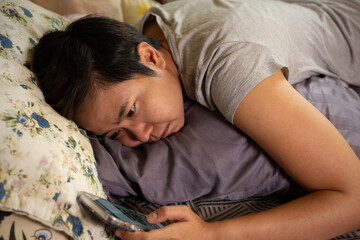 Asian woman face with despair and restlessness, reflects emotional unrest, loneliness and sadness . As she lies in bed experienced sleepless nights and the associated anxiety and stress.