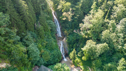 Fototapeta premium Waterfall flowing in the green forest. Local name manle waterfall. Aerial view