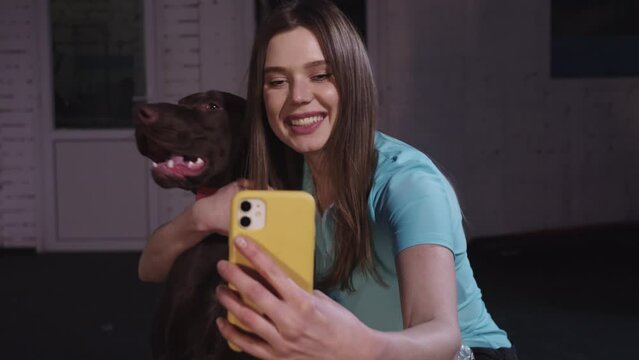 Cute woman taking selfie with her big brown dog
