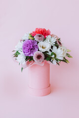 Beautiful bouquet of pink and white flowers on a pink pastel background.