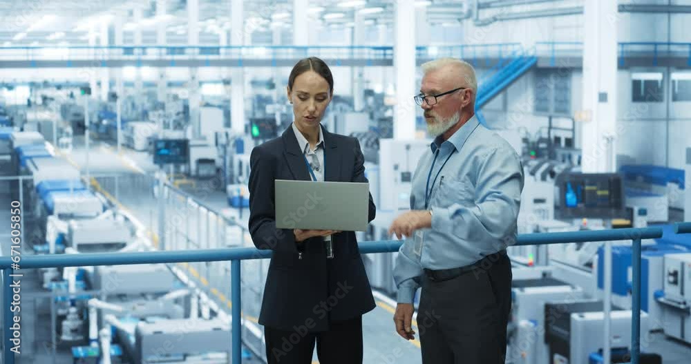 Poster Middle Aged Engineer and a Female Technician Having a Conversation and Using Laptop Computer. Specialists Monitoring, Analyzing Conditions at a Modern Electronics Factory with Automated Robotic Arms
