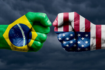 BRAZIL vs USA confrontation, religious conflict. Men's fists with painted flags of BRAZIL and USA.