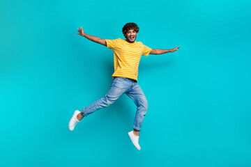 Fototapeta na wymiar Full size portrait of overjoyed carefree person jumping arms wings flying have good mood isolated on turquoise color background