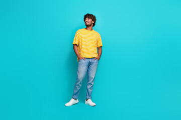 Full size photo of handsome young guy look empty space promo ad wear trendy striped yellow outfit...