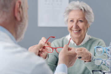 Happy elderly woman choosing new glasses