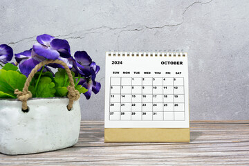 White calendar on office wooden desk with potted plant. 2024 New Year Concept