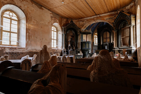 Lukova, Czech Republic, 29 October 2023: Abandoned catholic church of St. George or Jiri, Ghosts line pews, statues by Jakub Hadrava, figures made of plaster, Ghostly figures, Spirit at mass