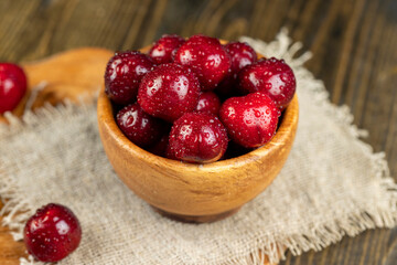 covered with drops of water ripe red cherries on the table