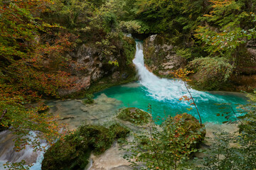 Naklejka premium The waterfalls and crystal clear, blue, turquoise and green waters of the Nacedero del Urederra, with its beech forest with its autumn colors in the Sierra de Urbasa-Andía. Navarre. Spain
