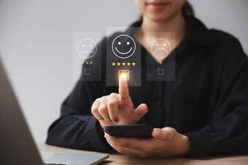 customer satisfaction survey concept businesswoman use smartphone Touch the happy smiley icon....