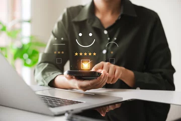 Fotobehang customer satisfaction survey concept businesswoman use smartphone Touch the happy smiley icon. Satisfied. 5 stars. Service experience rating. online application Satisfaction Review best quality. © Prae_Studio