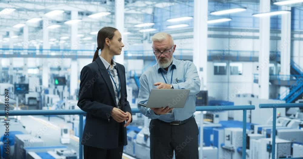 Poster Two Diverse Engineers Standing on a Platform, Using Laptop Computer at an Electronics Factory. Machines are Producing Electronic Components, Specialists Monitoring the Progress on Online Software