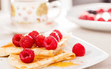 Breakfast of pancakes with fresh raspberries on table
