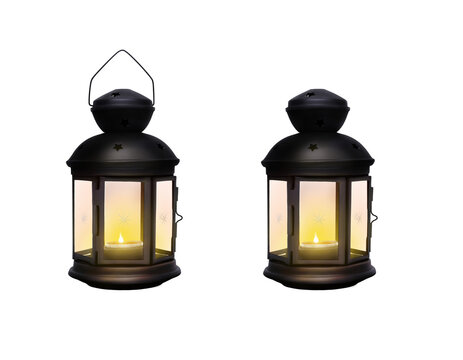 A traditional festive Christmas lantern made from black wrought iron metal glowing from a lit Christmas candle isolated against a transparent background.