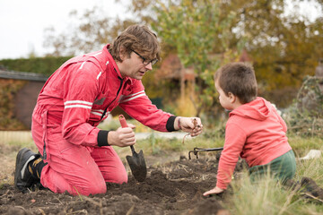 Little boy with his father playing as a craftsman and gardener in autumn
