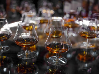 Glass of brandy or cognac on the bluring background