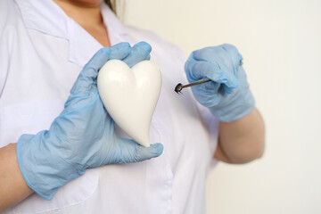 female scientist, doctor holding heart model, microprocessor, microchip, biochip tweezers for...