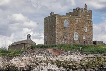 A building and derelict church on the top of a cliff