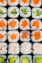 Set of japanese multi-colored sushi pieces vertical photo shot from top view with different mixed various rolls close-up