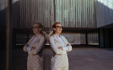 vertical portrait of a proud business woman standing hands crossed while looking at the horizon. female pride
