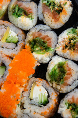 Japanese set of multi-colored sushi rolls vertical photo shot on top view with different mixed various pieces very close-up