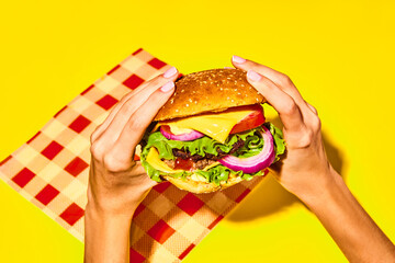 Woman holding delicious burger, hamburger with fresh bun, meat, cheese, lettuce and tomato over...