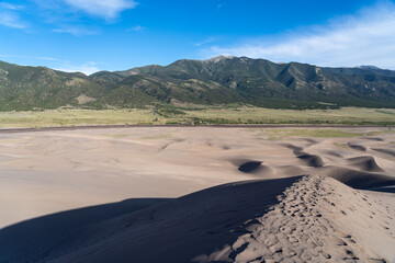 Great Sand Dunes National Park in Colorado on a sunny summer day, with mountains in the background