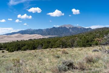 Great Sand Dunes National Park in Colorado on a sunny summer day, with mountains in the background