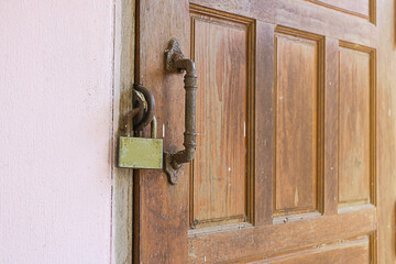 Locked wooden door with old iron key and folding door. Old wooden door with lock on vintage background