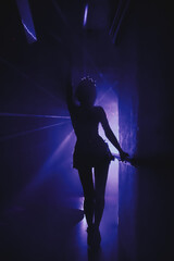Silhouette stylish show woman in stage costume on stage in night club party at dark neon background