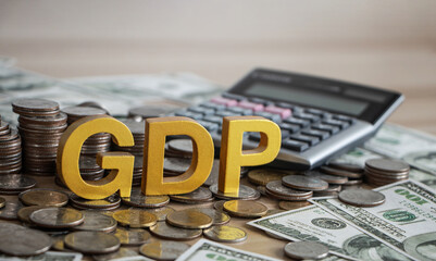 GDP, Gross domestic product concept. Gold gdp text and Coins stack with calculator on a beautiful background from dollar bills. Business and GDP, good distribution practice. Copy space.