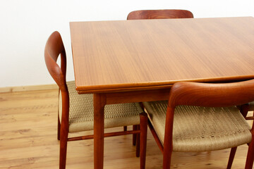A mid century teak dining table with four chairs from the 50s 60s Danish Design Vintage Dining solid wood Modern antique 50s 60s isolated on white wall in modern living room closeup side front view